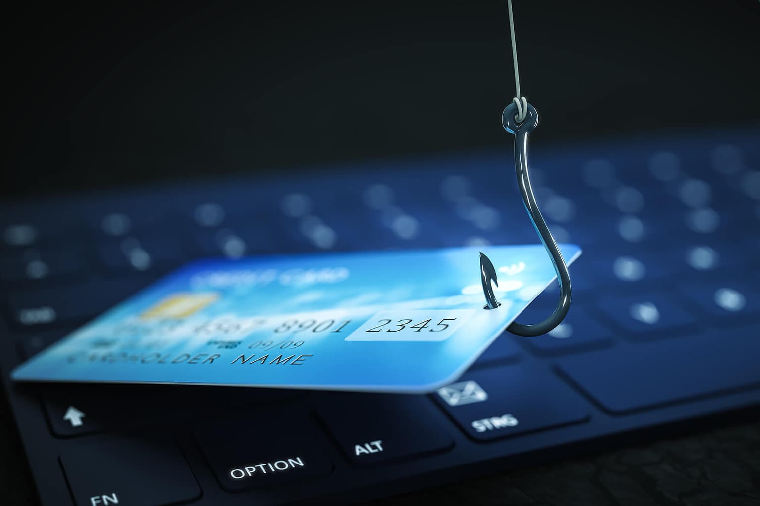 image of credit card on computer keyboard with fishing hook through the credit card